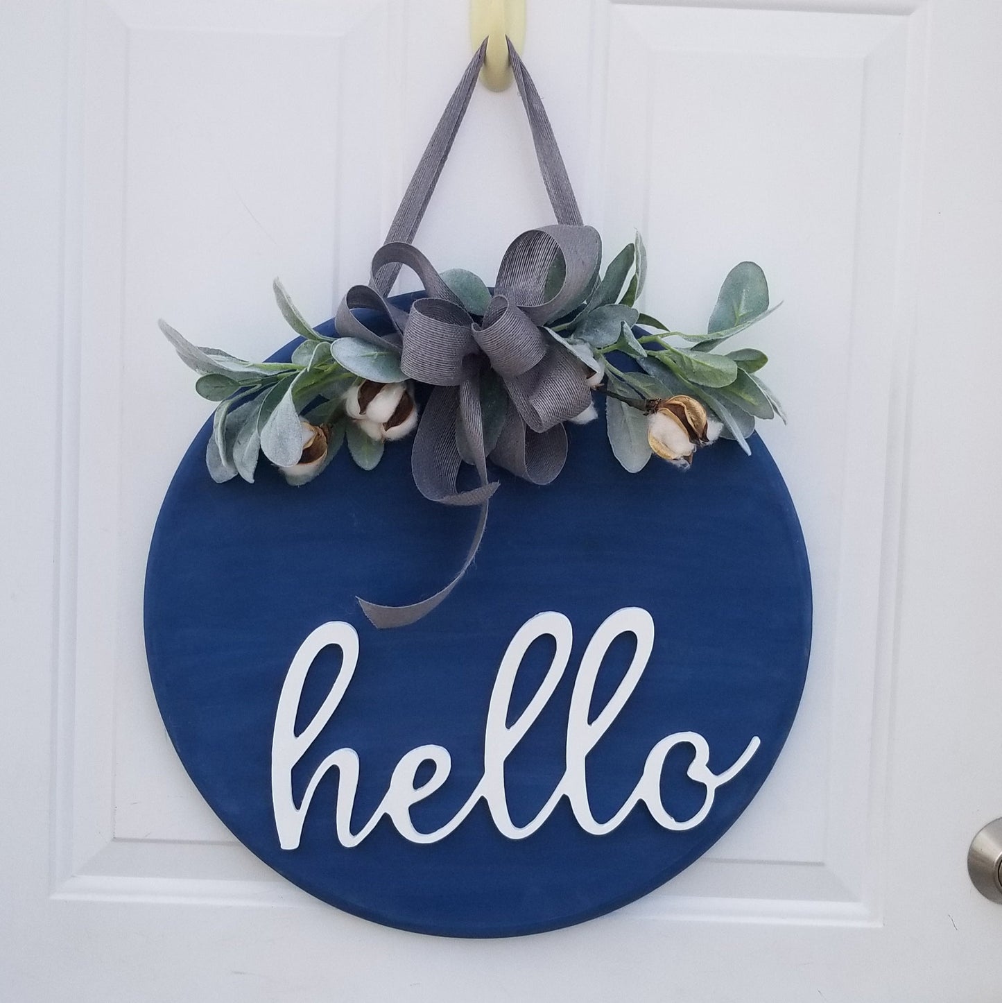 Hello doorhanger with greenery and bow